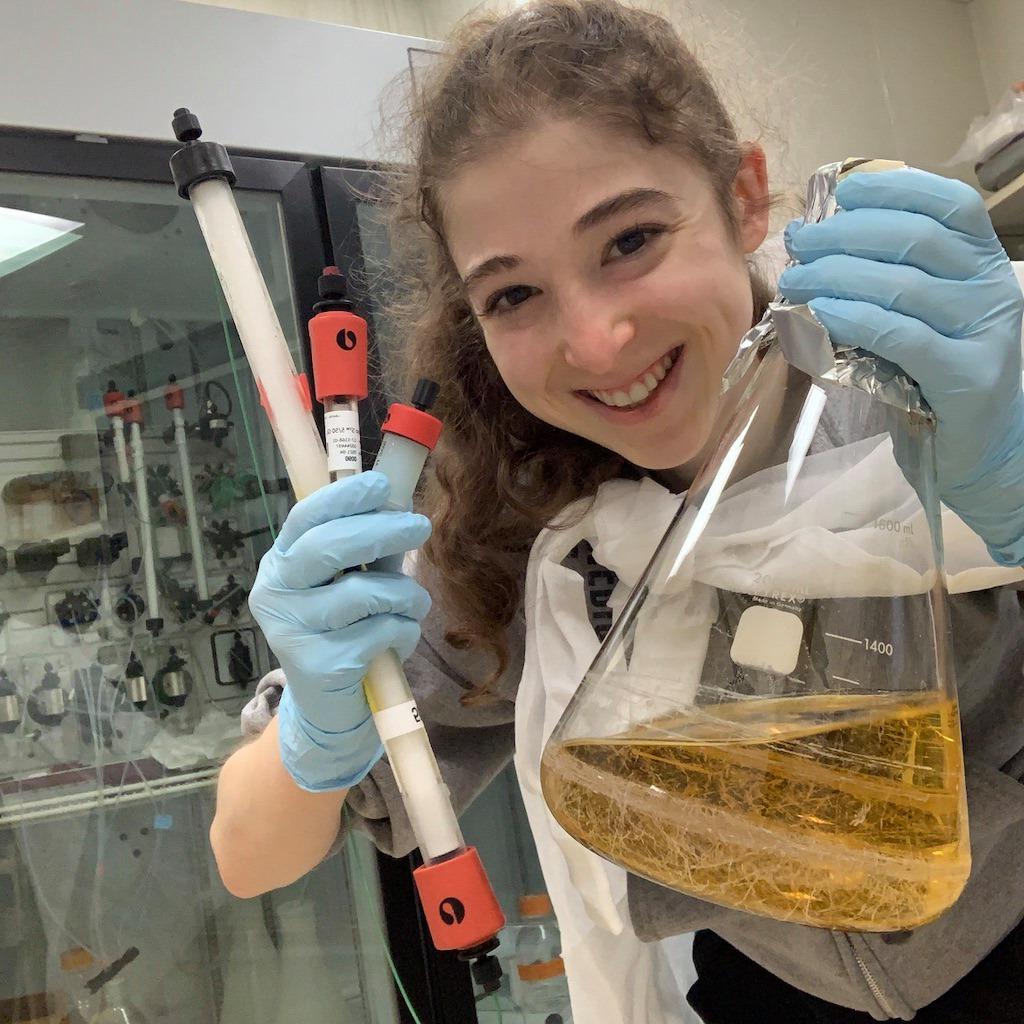 Brianna Bibel smiling and holding a beaker