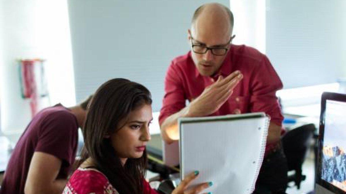 student and professor looking at notebook together