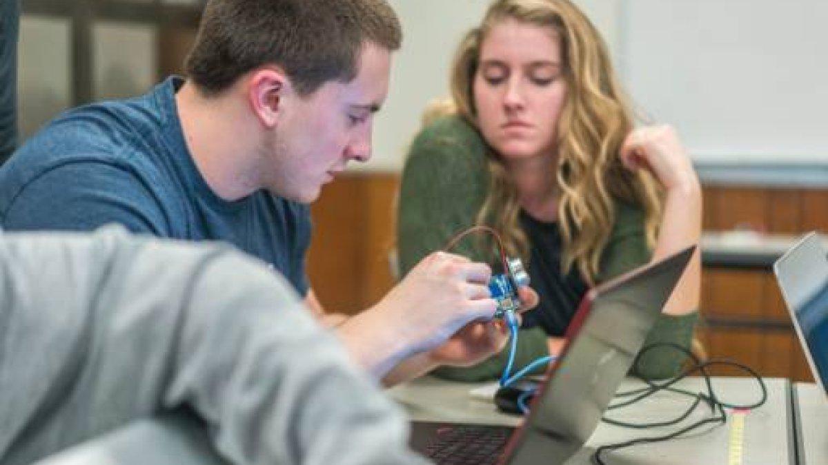 engineering students looking at laptop